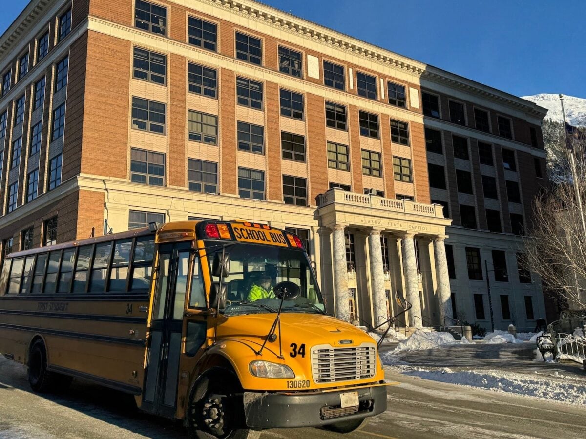 A school bus drives in front of the Alaska State Capitol on Monday, Feb. 3, 2025. (Photo by James Brooks/Alaska Beacon)