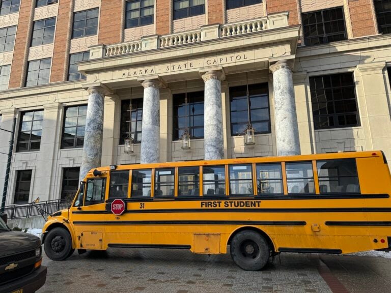 A school bus passes in front of the Alaska Capitol on Tuesday, Feb. 6, 2024. (Photo by James Brooks/Alaska Beacon)